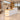 White reception counter with stepped oak tops and left display shelves in the same office, 45-degree view