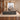 Gray wood executive desk with left storage return and geometric cabinet fronts in a furnished office, side view