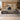 Gray wood executive desk with marble accents, warm lighting and right storage return in a furnished office, front view