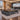 Glossy ebony executive desk with champagne trim and left return in a furnished office, 45-degree view