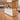 White reception desk with rounded light oak surround and LED front in a furnished office, 45-degree view