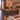 Walnut and charcoal L-shaped executive desk with LED front and file storage in a furnished office, 45-degree view
