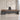 Lurpes red walnut and dark gray executive desk in a limestone office, standing camera view